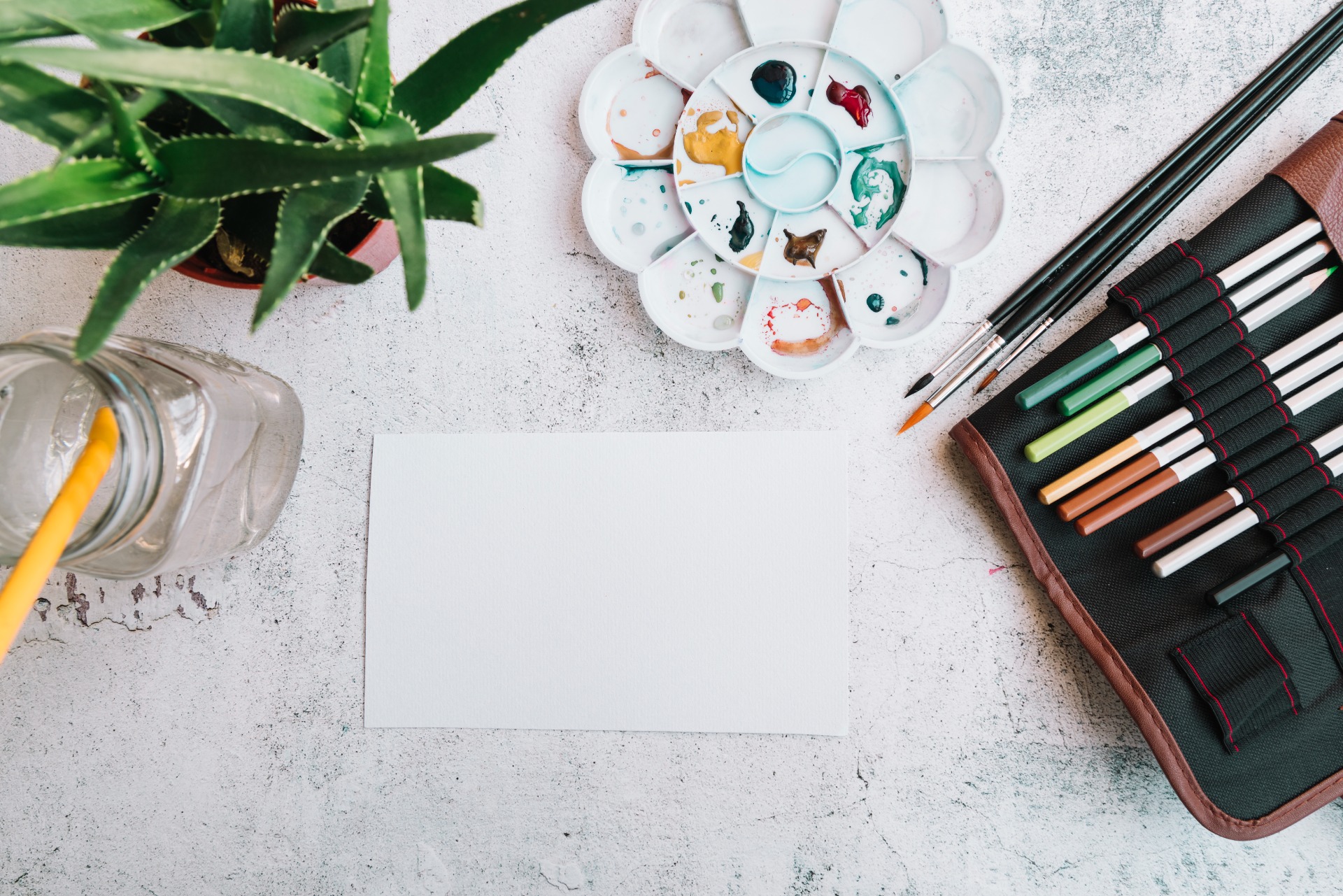 Painting materials and a miniature painting on a work table
